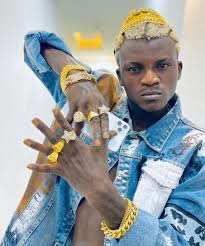 Mr. Jollof and others reacts to the video, "Is the make-up for me?" as Portable receives facials in preparation for his music video.