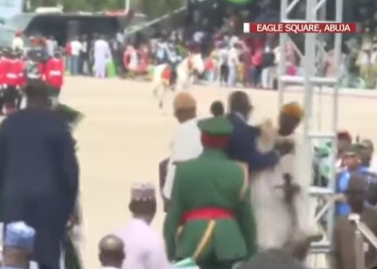 During the inauguration of the New President, a security assistant is seen on camera throwing a photographer off the stage.